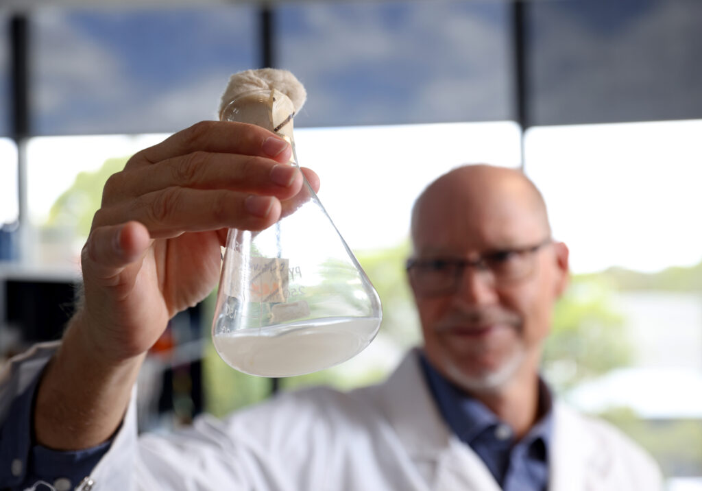 MicroBioGen Head of Research, Dr Philip Bell, holding a flask of non-GM Saccharomyces cerevisiae yeast